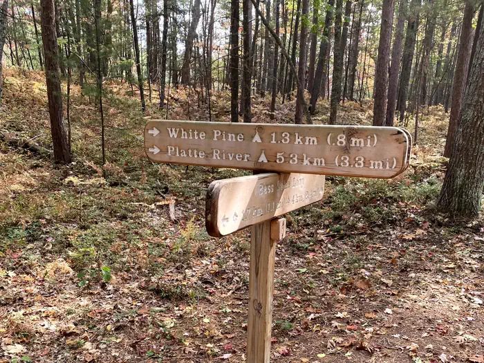 Wooden trail sign showing hiking distances