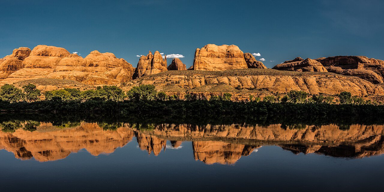 The Colorado River reflecting the cliffs near Moonflower Canyon, across from Jaycee Park Campground