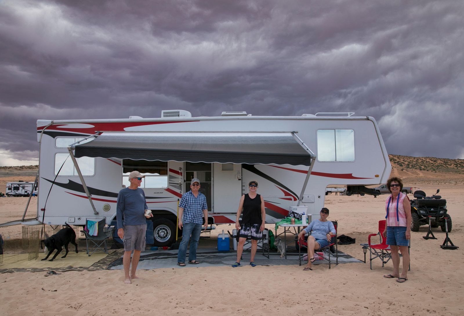 A family in front of their RV on the beach at Lone Rock